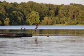 Kind springt mit Anlauf in den See