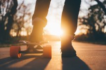 mit dem Skateboard Richtung Sonnenuntergang
